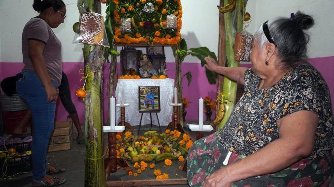 Personas arreglan hoy una ofrenda dedicada a sus familiares fallecidos, en el municipio de Juchitán, estado de Oaxaca (México). EFE/Jesús Méndez
