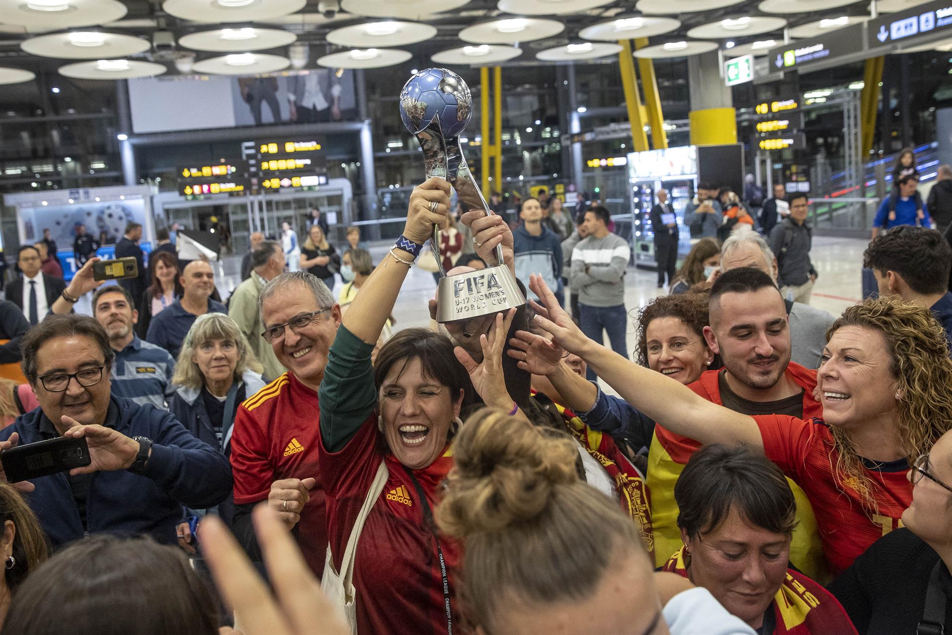 Las jugadoras de la selección española sub17 y sus familias levantan la copa a su llegada al aeropuerto Adolfo Suárez Madrid-Barajas este lunes, tras proclamarse campeonas del mundo ayer en India. La selección española femenina logró su segundo Mundial sub-17 consecutivo tras vencer en la final a la selección de Colombia el pasado domingo. EFE/ Daniel González
