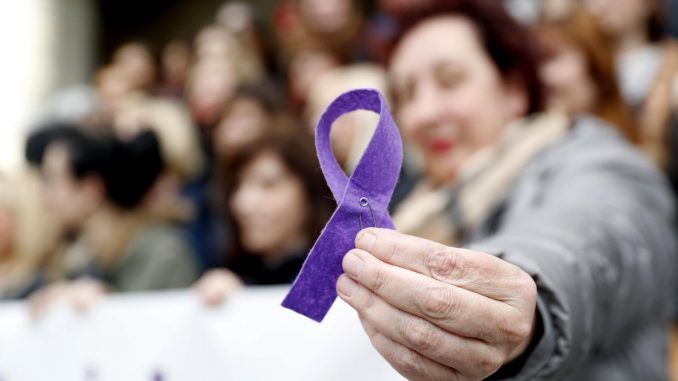 Imagen de archivo de una mujer sosteniendo un lazo morado. EFE/LUIS TEJIDO
