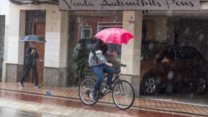 Viandantes se cubren con paraguas en las calles de Mahón, Menorca, este jueves. EFE/ David Arquimbau Sintes
