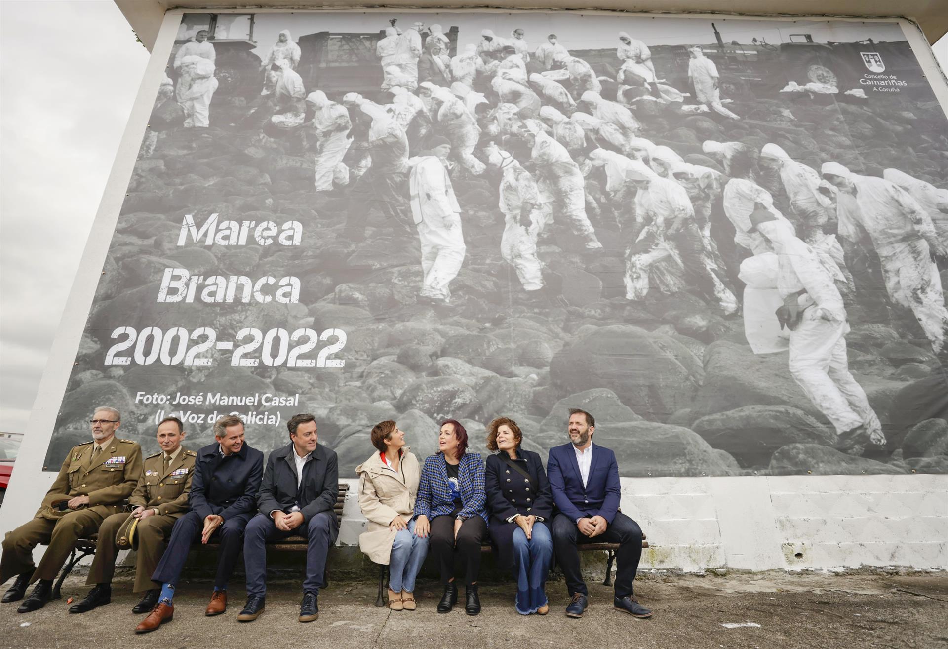 La ministra de Política Territorial y portavoz del Gobierno, Isabel Rodríguez (4d), durante el acto 'Marea Branca 2002-2022', homenaje de la Costa da Morte a los voluntarios que limpiaron las playas y rocas gallegas del chapapote que dejó el Prestige hace veinte años, evento en el que ha quedado instalada una lona de grandes dimensiones con una fotografía en recuerdo de aquellos voluntarios. EFE/Cabalar
