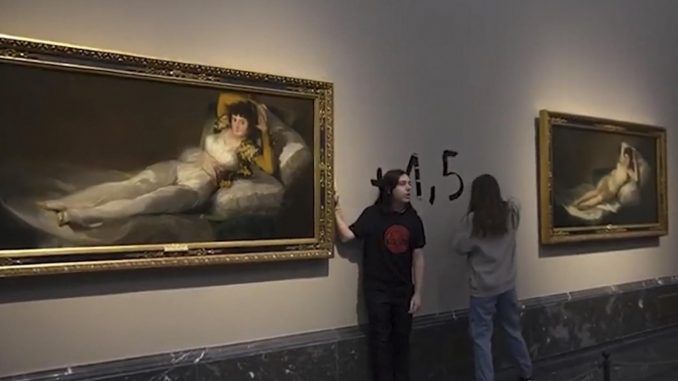 Captura de video del momento en el que dos activistas de la organización Futuro Vegetal se han pegado a los marcos de los cuadros de "La maja vestida" y "La maja desnuda" del Museo del Prado. EFE/Futuro Vegetal
