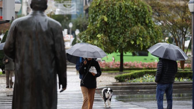 Varios peatones se protegen del agua este lunes en Bilbao, debido a la borrasca con chubascos acompañados de tormenta, que podrán ser fuertes y persistentes en el norte y que tenderán a remitir al final del día en la mitad sur. EFE/Luis Tejido
