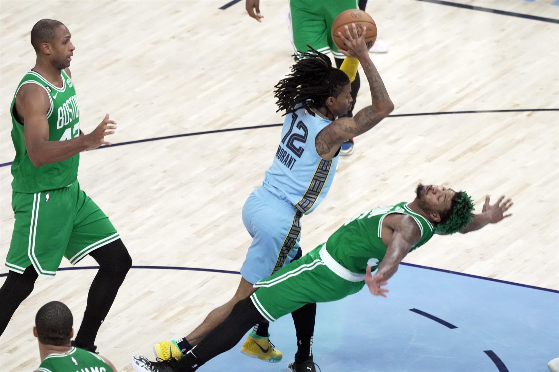 Ja Morand (12) de los Memphis Grizzlies pasa a un compañero de equipo mientras que Marcus Smart (36) de los Boston Celtics cae al piso hoy, en la segunda mitad del juego en el FedEx Forum en Memphis, Tennessee (EE.UU.). EFE/Karen Pulfer Focht
