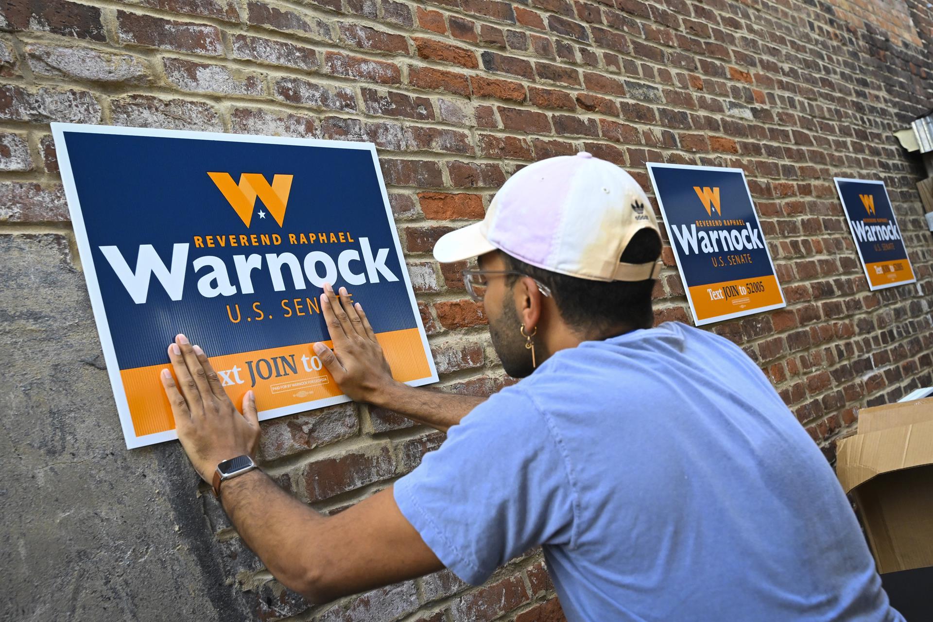 Los partidarios del senador demócrata Raphael Warnock colocaron carteles de campaña durante un evento de campaña en Macon, Georgia, EE. UU. EFE/EPA/JOHN AMIS
