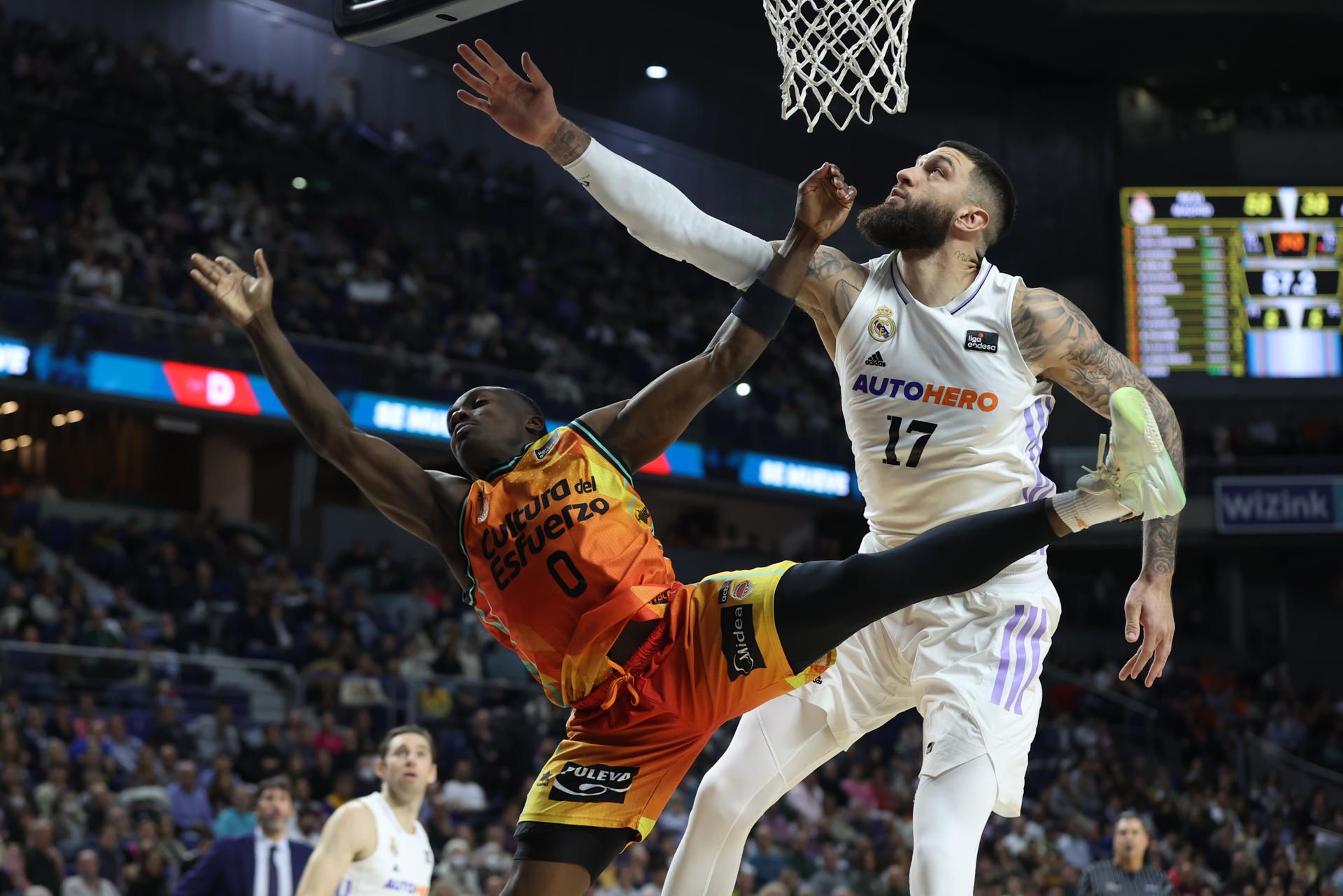 El pívot francés del Real Madrid Vincent Poirer (d) pelea una posesión con el base estadounidense del Valencia Basket Jared Harper durante un encuentro correspondiente a la Liga ACD en el WiZink Center de Madrid, este domingo. EFE/ Kiko Huesca
