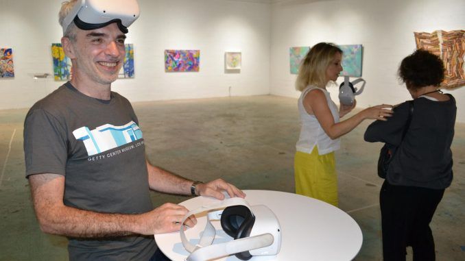 El artista Carlos Muslera posa hoy con las gafas de realidad virtual que se utilizan para observar el arte creado con obras NFT, en el Center for Visual Communication en Miami (EE.UU). EFE/ Antoni Belchi
