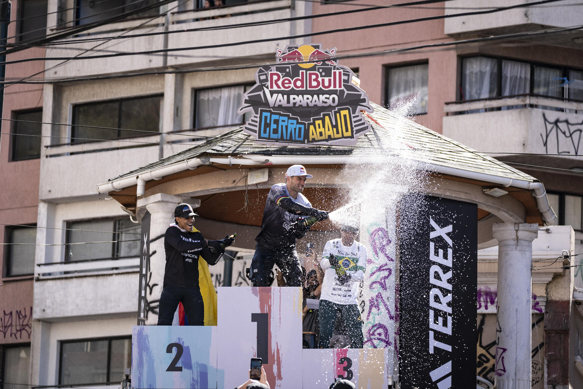 Fotografía cedida por la organización Red Bull del ciclista de República Checa, Tomás Slavik (c), celebra hoy durante su participación en el Red Bull Valparaiso Cerro Abajo, en la ciudad de Valparaíso, Chile (CHILE). EFE/ ORGANIZACION RED BULL
