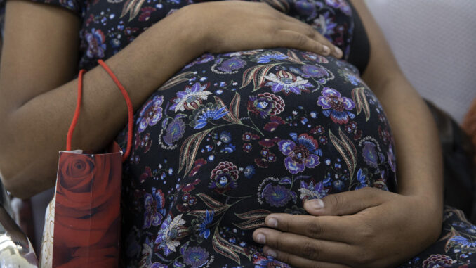 Fotografía de archivo fechada el 7 de marzo de 2023 que muestra a una joven en estado de embarazo avanzado mientras espera ser atendida en la maternidad La Altagracia, en Santo Domingo (República Dominicana). EFE/ Orlando Barría
