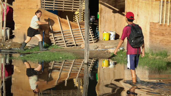 Un hombre camina en medio de una inundación en el barrio La Chacarita, a la orilla de la bahía de Asunción (Paraguay). EFE/ Rubén Peña
