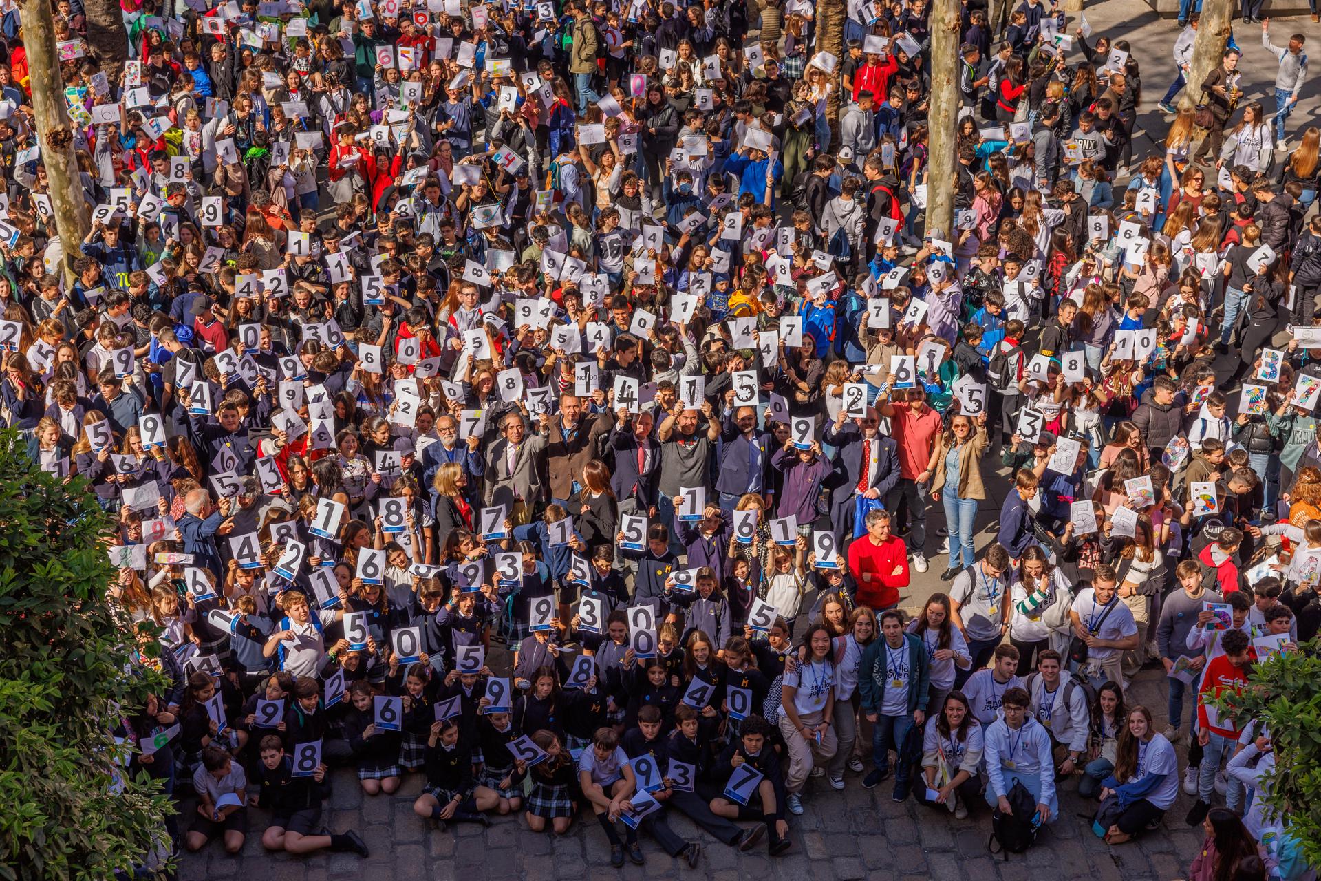 Cerca de 2.000 estudiantes tras formar este martes en Sevilla una cadena humana de decimales del número pi (3,141592...) que ha llegado a abarcar una distancia próxima al kilómetro al conectar el Rectorado de la Universidad sevillana y la sede del Ayuntamiento, en el centro de la ciudad, organizada por el Consistorio, la Universidad hispalense y la SAEM (Sociedad Andaluza de Educación Matemática) y celebrar así el Día Internacional de las Matemáticas.EFE/Julio Muñoz
