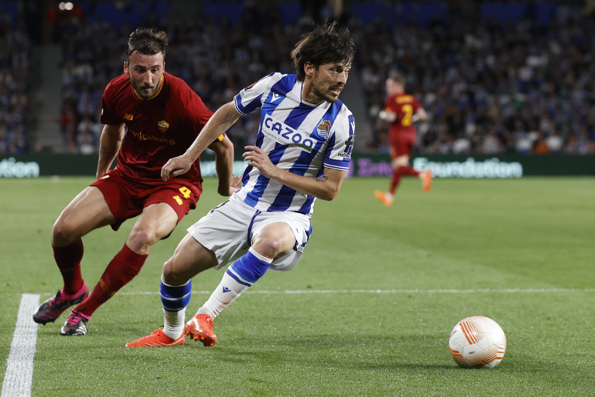 El centrocampista de la Real Sociedad, David Silva (d) disputa un balón con el centrocampista italiano de la Roma Bryan Cristante (i) durante el partido de octavos de final de la Europa League que ambos equipos disputan este jueves en el estadio Reale Arena de San Sebastián (Euskadi). EFE/ Javier Etxezarreta
