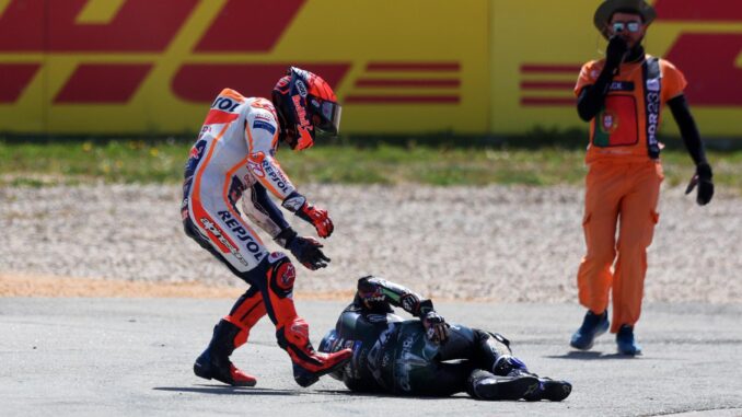 El piloto español de MotoGP Marc Márquez del Repsol Honda Team intenta ayudar al piloto portugués de MotoGP Miguel Oliveira del CryptoDATA RNF MotoGP Team tras una caída durante la carrera de MotoGP en el Gran Premio de Motociclismo de Portugal en el circuito internacional de Algarve, Portimao.EFE/EPA/NUNO VEIGA
