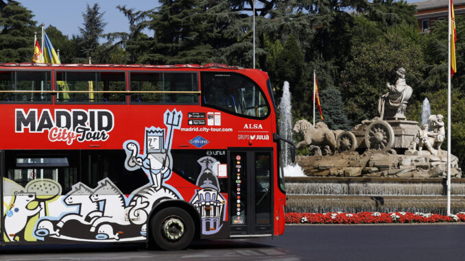 Imagen de archivo de un autocar turístico de Madrid, a su paso por la fuente de Cibeles. EFE/ Chema Moya
