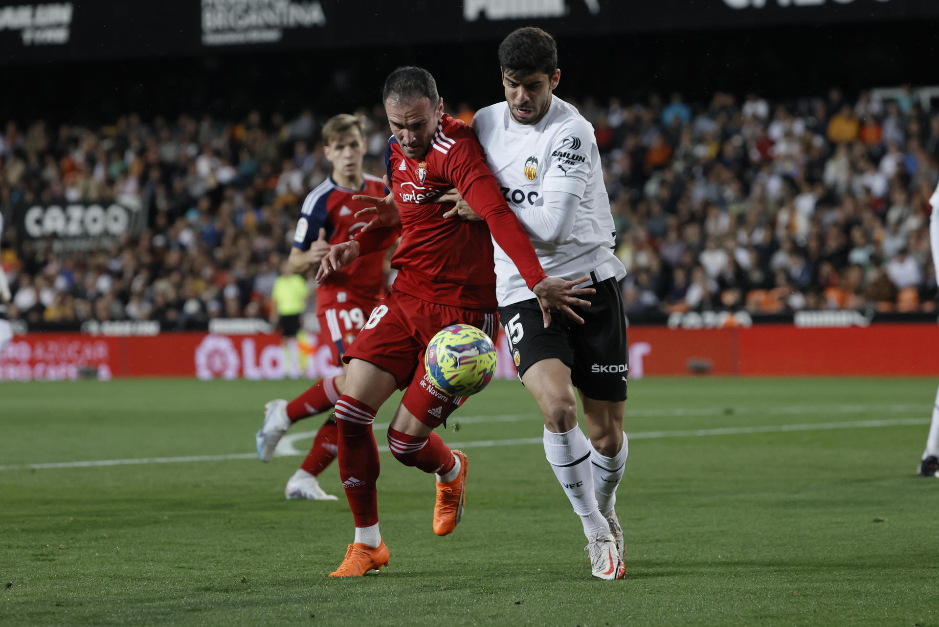 El defensa turco del Valencia, Cenk Ozkacar (d), disputa el balón ante el delantero de Osasuna, Kike García, durante el partido correspondiente a la jornada 25 de primera división en el estadio Mestalla de Valencia. EFE/ Juan Carlos Cárdenas
