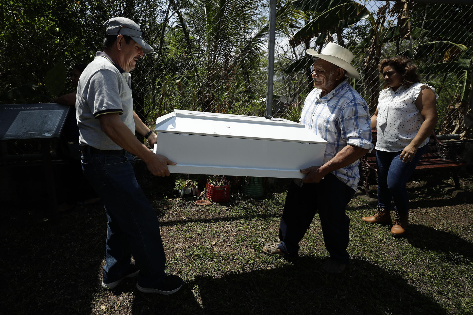 Dos hombres trasladan uno de los féretros que contienen los restos de víctimas de la masacre El Mozote, exhumados en 2016 y entregados el pasado miércoles a sus familiares, hoy en Meanguera (El Salvador). EFE/Rodrigo Sura
