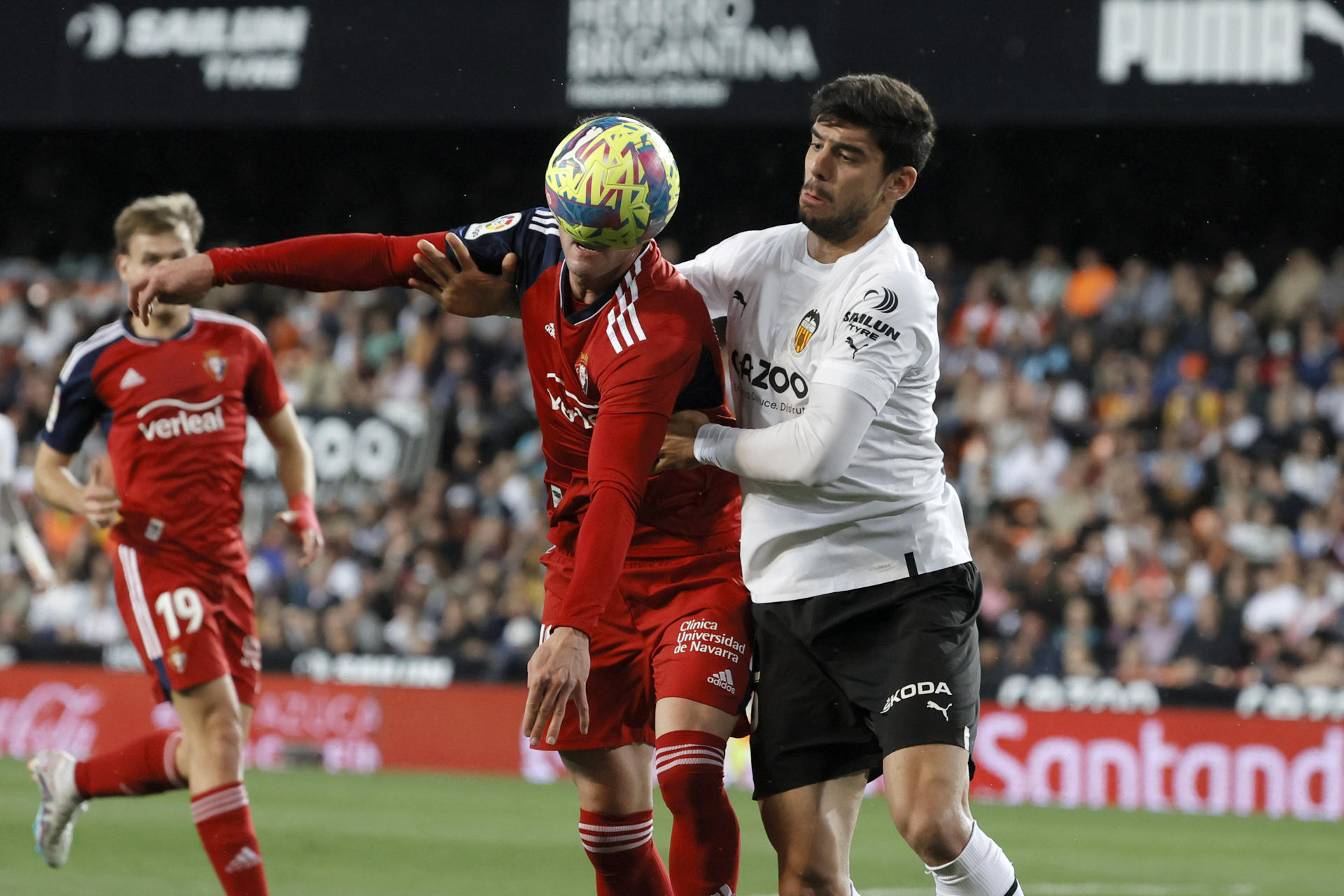 El defensa turco del Valencia, Cenk Ozkacar (d), disputa el balón ante el delantero de Osasuna, Kike García, durante el partido correspondiente a la jornada 25 de primera división en el estadio Mestalla de Valencia. EFE/ Juan Carlos Cárdenas
