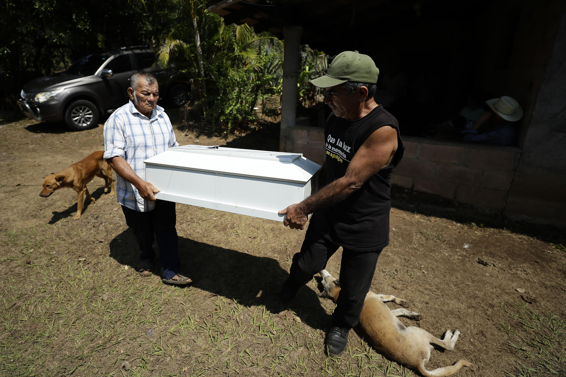 Dos hombres trasladan uno de los féretros que contienen los restos de víctimas de la masacre El Mozote, exhumados en 2016 y entregados el pasado miércoles a sus familiares, hoy en Meanguera (El Salvador). EFE/Rodrigo Sura
