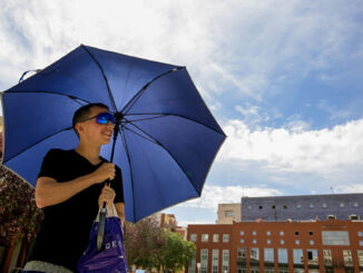 Un joven se protege del sol con un paraguas en Ciudad Real. EFE/Jesús Monroy