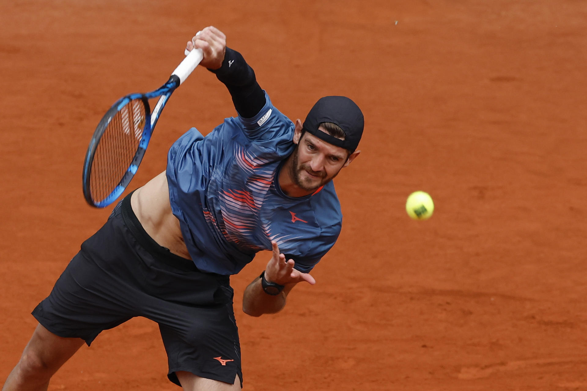 El italiano Andrea Vavassori hace un saque ante el tenista ruso Daniil Medvedev durante su partido de segunda ronda del torneo Masters 1000 Mutua Madrid Open de tenis disputado este viernes en la Caja Mágica, en Madrid. EFE/Chema Moya
