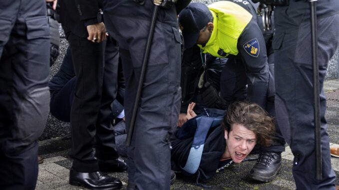 La Policía detiene a un manifestante que irrumpió a gritos durante la visita del presidente francés, Emmanuel Macron, a la Universidad de Ámsterdam. EFE/EPA/Ramon van Flymen
