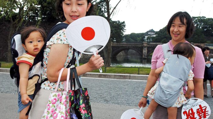 Imagen de archivo de mujeres japoneses con sus bebés celebrando en el Palacio Imperial la noticia del nacimiento del hijo varón de la princesa Kiko. EFE/Robert Gilhooly
