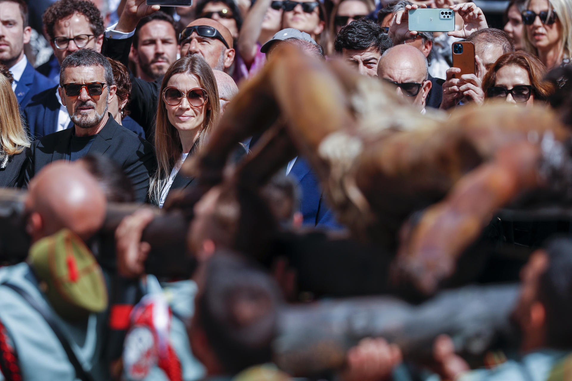 El actor Antonio Banderas (i) y su pareja, Nicole Kimpel  (2i), presencian el relevo del estandarte y procesión del Cristo de la Buena Muerte, en la plaza de Fray Alonso de Santo Tomás en Málaga este Jueves Santo. EFE/Jorge Zapata
