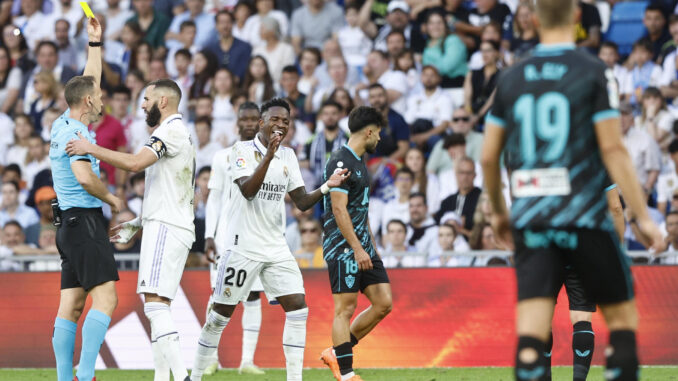 El delantero brasileño del Real Madrid Vinícius Jr. protesta la cartulina amarilla que le saca el árbitro Cuadra Fernández durante el encuentro correspondiente a la jornada 32 de LaLiga Santander que Real Madrid y UD Almería disputan en el Santiago Bernabéu, en Madrid. EFE/ Rodrigo Jiménez
