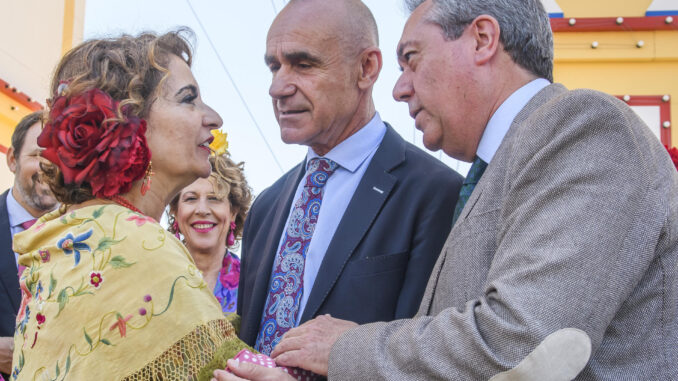 La vicesecretaria general del PSOE y ministra de Hacienda, María Jesús Montero (i), acompañada por el secretario general del PSOE de Andalucía, Juan Espadas (d), y el alcalde de Sevilla y candidato a la reelección, Antonio Muñoz (i) durante su visita este domingo a la Feria de Abril de Sevilla. EFE/ Raúl Caro.