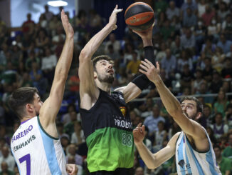 El pívot croata del Joventut Ante Tomic (c) intenta superar a Jonathan Barrerio (i) y a David Kravish (d), ambos de Unicaja, durante el partido de la jornada 30 de la Liga ACB que Unicaja Málaga y Joventut de Badalona juegan hoy domingo en el Palacio de los Deportes José María Martín Carpena. EFE/Daniel Pérez