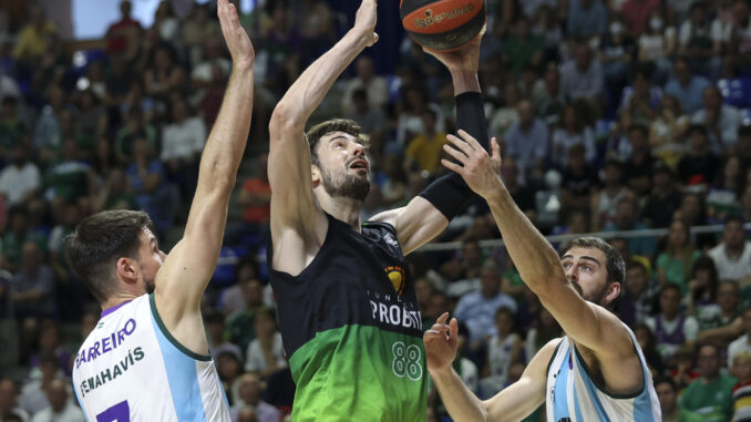 El pívot croata del Joventut Ante Tomic (c) intenta superar a Jonathan Barrerio (i) y a David Kravish (d), ambos de Unicaja, durante el partido de la jornada 30 de la Liga ACB que Unicaja Málaga y Joventut de Badalona juegan hoy domingo en el Palacio de los Deportes José María Martín Carpena. EFE/Daniel Pérez
