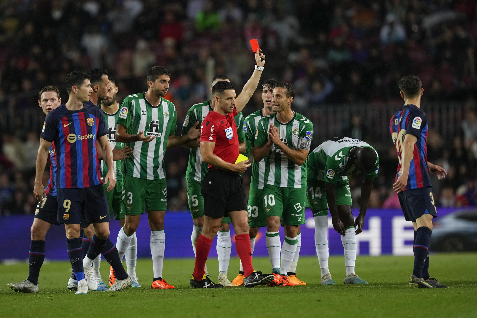 El árbitro Del Cerro Grande saca tarjeta roja a Edgar González, del Betis, durante el partido de la jornada 32 de LaLiga Santander que enfrenta al FC Barcelona y al Real Betis en el Spotify Camp Nou de la Ciudad Condal. EFE/ Alejandro García
