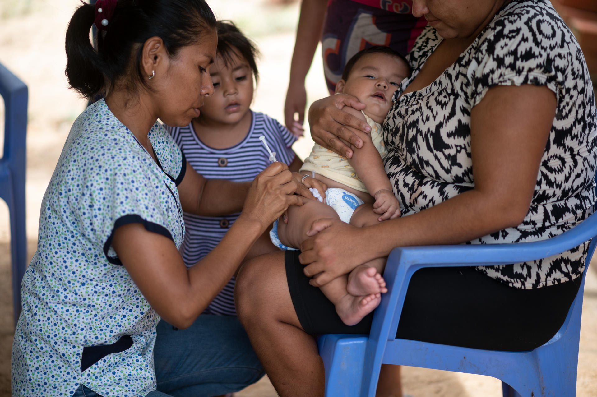 Fotografía cedida por el Fondo de las Naciones Unidas para la Infancia (UNICEF) donde aparece la enfermera Mercedes Parada mientras administra una vacuna a Ciro, de 7 meses. EFE/ Radoslaw Czajkowskito / UNICEF
