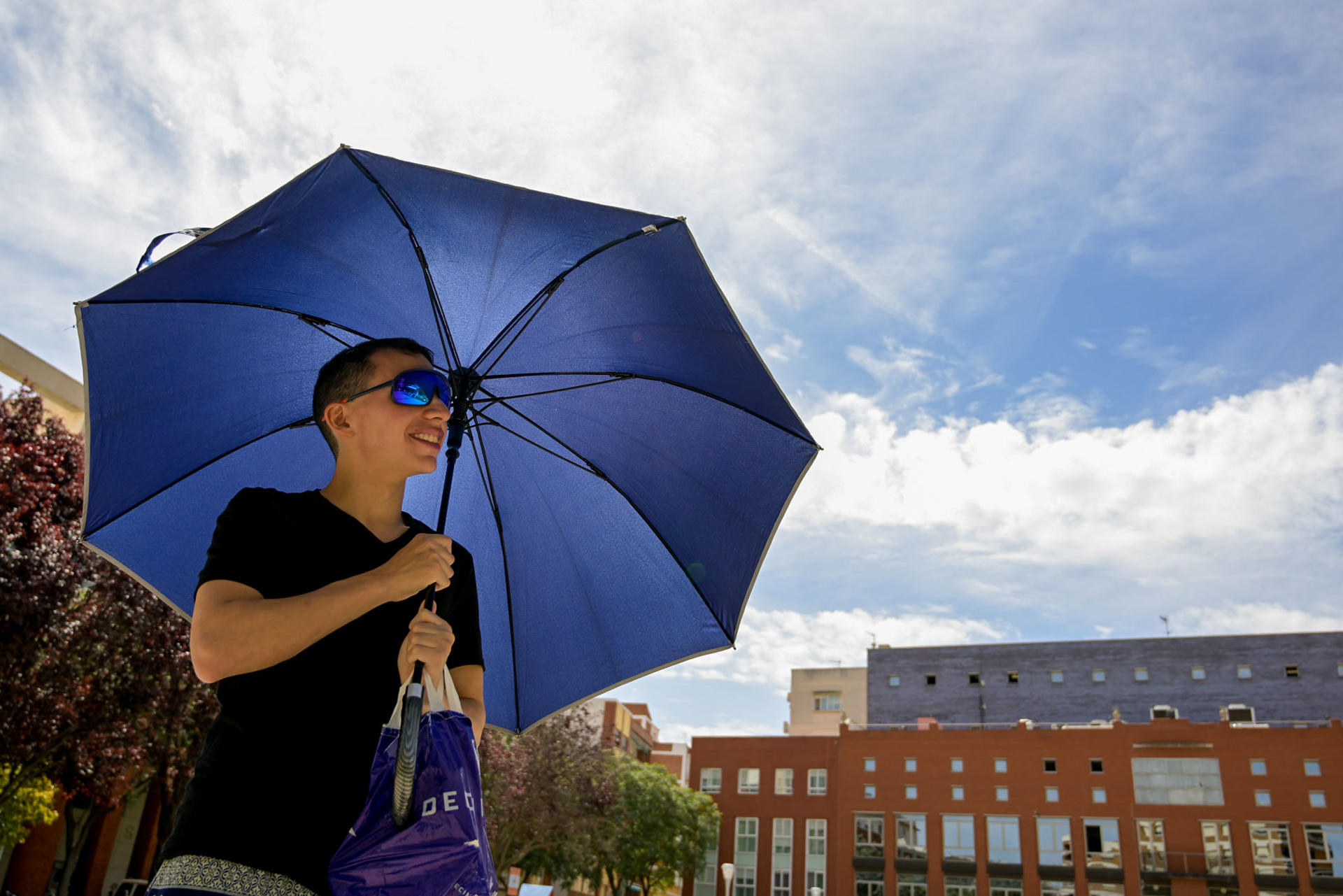 Un joven se protege del sol con un paraguas, este jueves en Ciudad Real. EFE/Jesús Monroy
