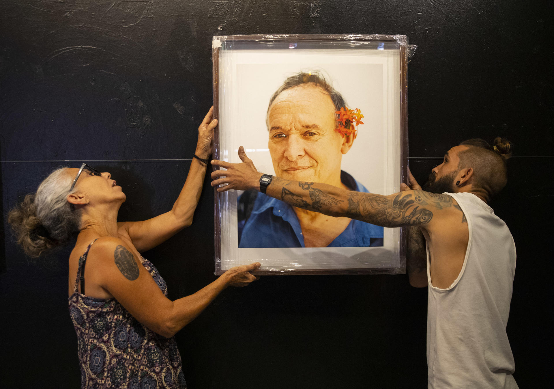 Dos personas montan en la pared una foto tomada por la actriz y fotógrafa cubano-mexicana Monik Molinet para su presentación de la exposición Masculinidades, hoy, en el Hotel Boutique Claxon en La Habana (Cuba). EFE/Yander Zamora
