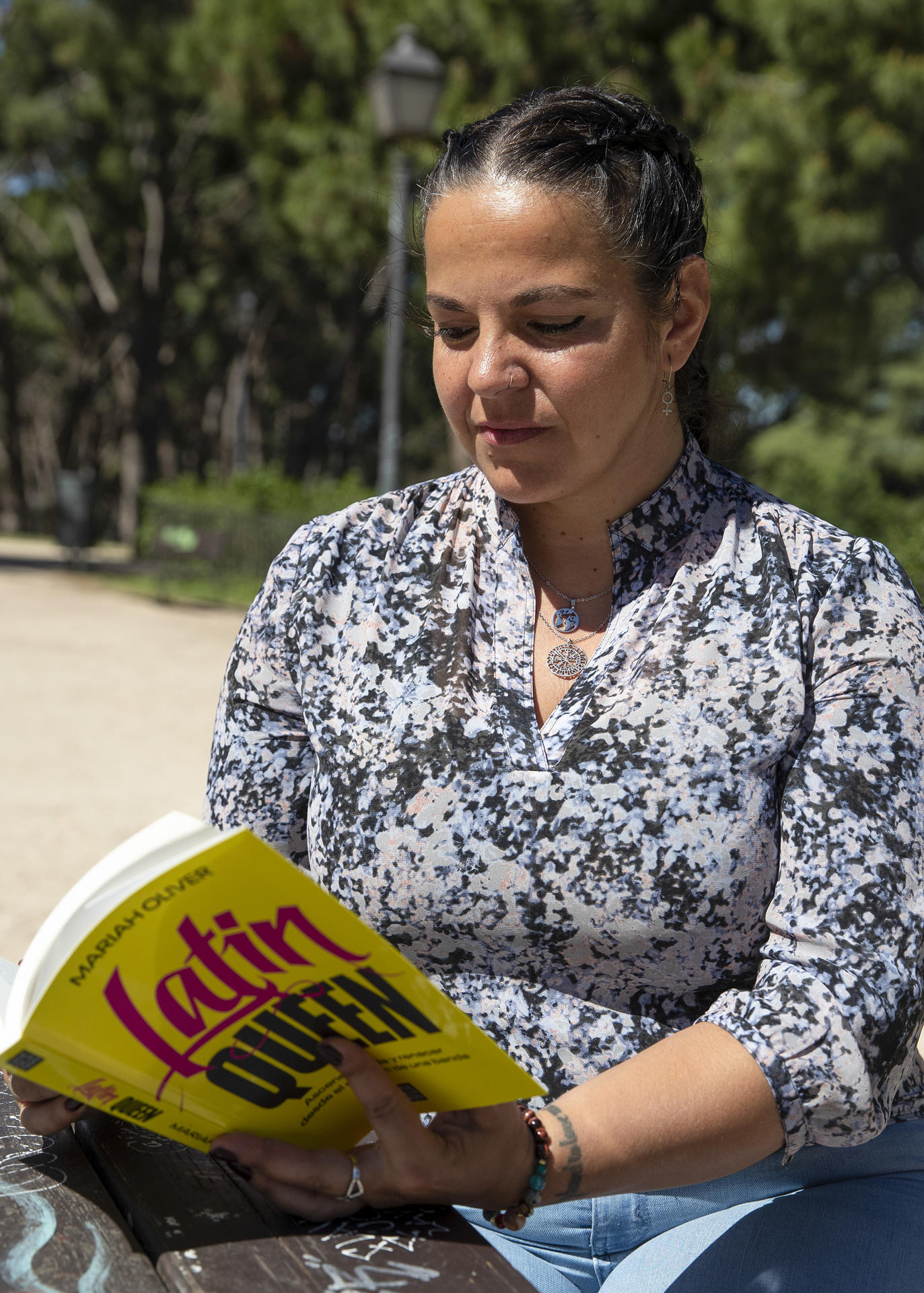 Mariah Oliver (Madrid, 1982) fue la primera "latin queen" en España, la primera mujer que formó parte de una banda juvenil. Tras pasar por la cárcel y sufrir un periplo judicial de más de una década, ha aportado su experiencia a una investigación sobre estos grupos en ciudades como Madrid, donde se necesita "una tregua" que solo puede alcanzarse con la "mediación". En la imagen, Oliver posa en una entrevista con EFE en las mesas grafiteadas del Parque del Oeste de la capital. EFE/ J.p. Gandul
