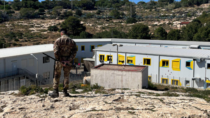 Un soldado del Ejército italiano vigila el único centro de acogida primaria de inmigrantes en la isla de Lampedusa. EFE/Gonzalo Sánchez
