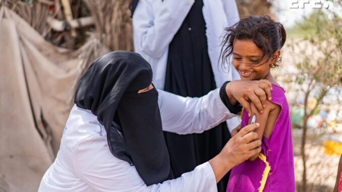 Fotografía cedida por el Fondo de las Naciones Unidas para la Infancia (UNICEF) donde aparece la enfermera Ghada Ali Obaid, de 53 años, mientras vacuna a Aswar Saddiq Othman, de 9 años en la gobernación de Adén (Yemen). EFE/ Saleh Hayyan / UNICEF/
