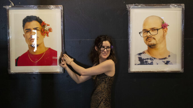 La actriz y fotógrafa cubano-mexicana Monik Molinet ayuda en el montaje de su presentación de la exposición Masculinidades, hoy, en el Hotel Boutique Claxon en La Habana (Cuba). EFE/Yander Zamora
