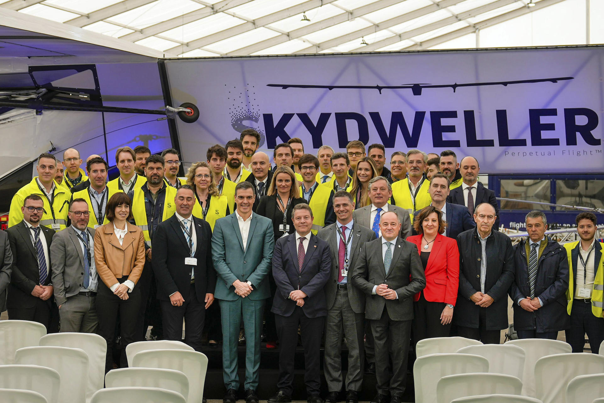 El presidente del Gobierno, Pedro Sánchez (5i), y el presidente de la Junta de Castilla-La Mancha, Emiliano García-Page (6i), posan para una foto de grupo con los trabajadores de la empresa Skydweller durante su visita para conocer el primer avión no tripulado y 100 % solar, fabricado por Skydweller, en el aeropuerto de Albacete, este lunes. EFE/ Manu
