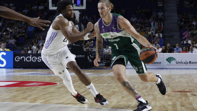 El pívot estadounidense del Unicaja Dylan Osetkowski (d) disputa una posesión ante Guerschon Yabusele (d) alero francés del Real Madrid durante el partido correspondiente a la jornada 31 de la Liga Endesa disputado este domingo en el Palacio de Los Deportes de Madrid. EFE/J.J. Guillén
