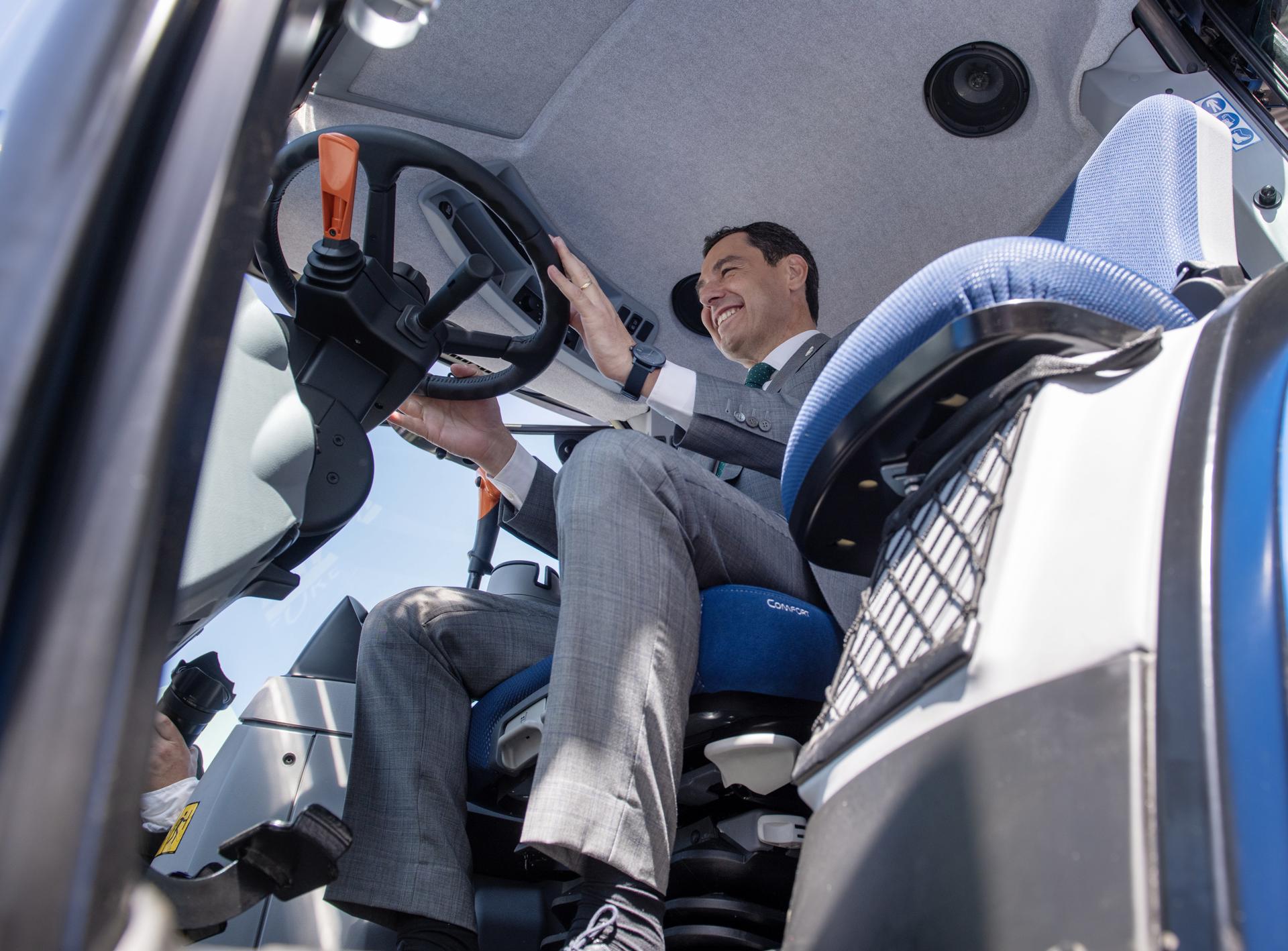 El presidente de la Junta de Andalucía, Juanma Moreno, dentro de un tractor durante la visita realizada este jueves a la feria internacional del aceite, Expoliva, que se celebra en Jaén donde ha rogado al Gobierno de la nación que tenga "sensibilidad" y ponga en marcha las obras hidráulicas pendientes porque "Andalucía no puede funcionar sin agua". EFE/José Manuel Pedrosa.
