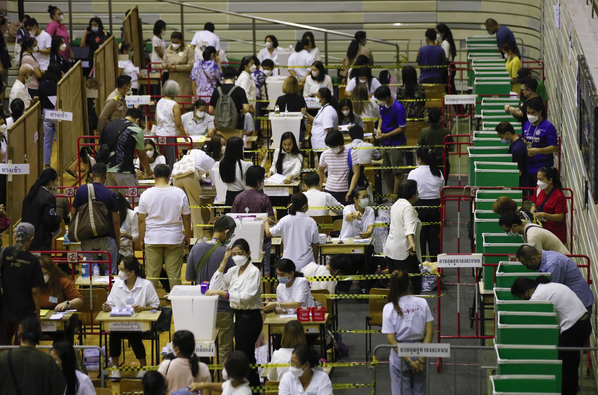 Más de dos millones de tailandeses están este domingo llamados a votar con una semana de adelanto para las elecciones legislativas que el próximo domingo 14 de mayo pueden marcar un cambio de rumbo en el país asiático. 
Según la Comisión Electoral, 2,3 millones de tailandeses se habían registrado para depositar hoy su papeleta, una semana antes que el resto de los 52 millones de ciudadanos con derecho a voto, lo que provocó las primeras colas en los colegios electorales de la capital, Bangkok, y de otras grandes ciudades. 
Los comicios parecen destinados a ser un duelo entre dos fuerzas opositoras: Puea Thai, liderado por Paethongtarn Shinawatra (hija del exprimer ministro Thaksin Shinawatra) y el partido reformista Move Forward, encabezado por Pita Limjaroenrat, que está subiendo en los últimos sondeos. 
En tercer lugar y muy lejos de ambos se sitúa la nueva fuerza conservadora United Thai Nation, encabezada por el actual primer ministro, el general Prayut Chan-ocha. 
Prayut era jefe del Ejército cuando tomó el poder en un golpe de Estado incruento en mayo de 2014 tras meses de manifestaciones antigubernamentales que habían impedido la celebración de unas elecciones ese año. 
EFE/EPA/RUNGROJ YONGRIT
