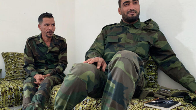 Mohamed Nafi (i) y Brahim Gali (d), veterano y novato del brazo armado del Frente Polisario, respectivamente, posan para EFE en uno de los campamentos de refugiados saharauis en territorio argelino el 16 de mayo de 2023. Muchos jóvenes saharauis con estudios superiores se han unido a la lucha armada en el movimiento independentista desde el fin de la tregua con Marruecos en 2020. La larga espera en el inhóspito exilio de los campamentos, con el único horizonte de un desierto ingrato e infinito, ha llevado a una nueva generación de saharauis a creer de nuevo en la lucha armada como única vía. EFE/ Laura Fernández Palomo
