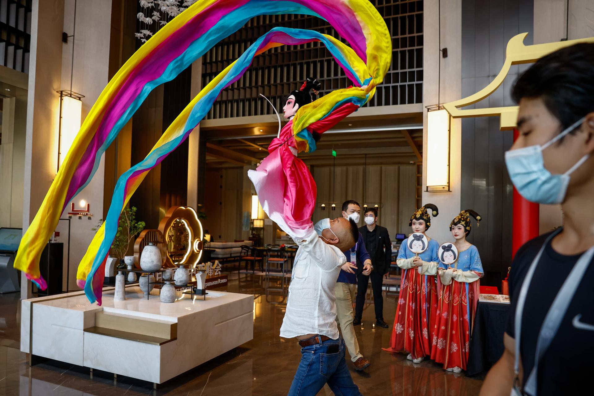 Un hombre ensaya un baile de Dunhuang con una muñeca antes de la Cumbre China-Asia Central en un hotel en Xi'an, provincia de Shaanxi, China, el 17 de mayo de 2023. EFE/EPA/MARK R. CRISTINO
