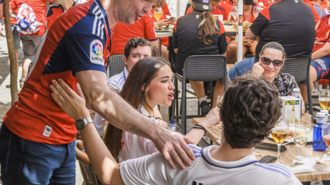 Aficionados del Osasuna y del Real Madrid llenan las calles céntricas de Sevilla, a unas horas de disputarse la Final de la Copa del Rey entre ambos equipos este sábado.- EFE / Raúl Caro.
