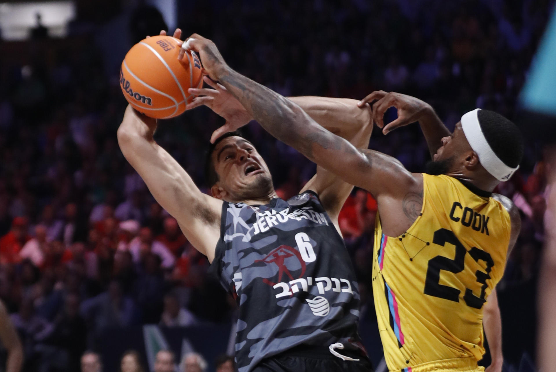 El alero estadounidense del Lenovo Tenerife Elgin Rashad Cook (d) disputa una posesión con el guardia israelí del del Hapoel Jerusalem israelí Noam Dovra (i) este viernes durante la primera semifinal de la Liga de Campeones FIBA en el Palacio de los Deportes José María Martín Carpena de Málaga. EFE/Jorge Zapata
