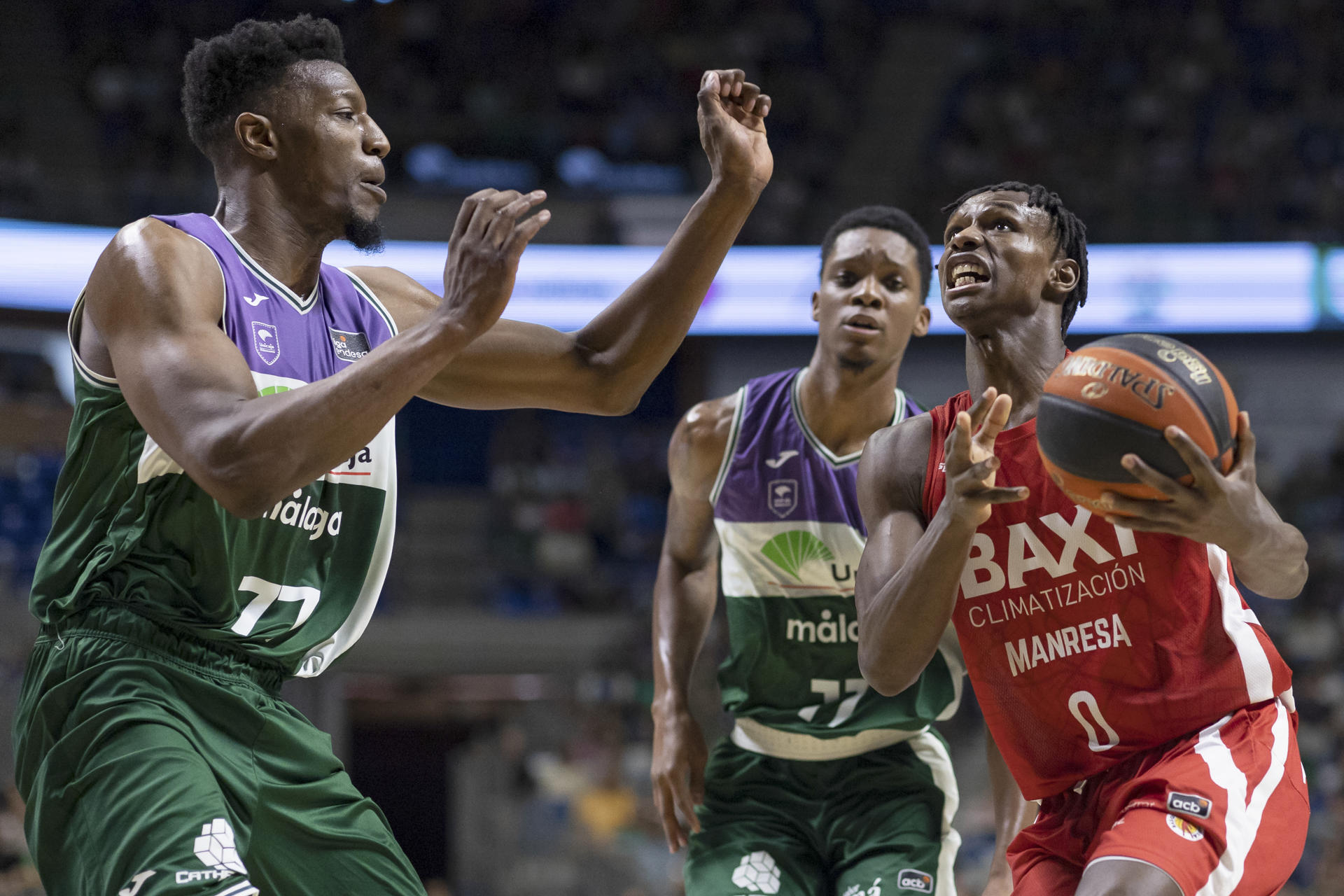 El escolta senegalés del Baxi Manresa, Brancou Badio (d), con el balón ante la defensa del pivot de Unicaja, Yankuba Sima (i), durante el encuentro correspondiente a la fase regular de la Liga Endesa disputado hoy miércoles en el Palacio de los Deportes José María Martín Carpena, en Málaga. EFE/Carlos Díaz.
