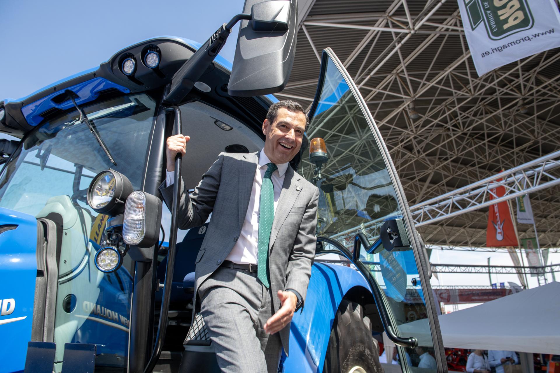 -El presidente de la Junta de Andalucía, Juanma Moreno, baja de un tractor durante la visita realizada este jueves a la feria internacional del aceite Expoliva, que se celebra en Jaén. Moreno ha pedido al Gobierno de la nación que tenga "sensibilidad" y ponga en marcha las obras hidráulicas pendientes porque "Andalucía no puede funcionar sin agua". EFE/José Manuel Pedrosa
