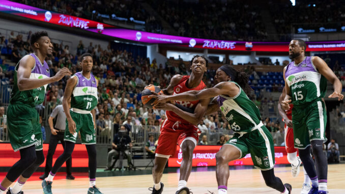 El escolta senegalés del Baxi Manresa, Brancou Badio (c), con el balón ante la defensa del base estadounidense de Unicaja, Kendrick Perry, durante el encuentro correspondiente a la fase regular de la Liga Endesa disputado hoy miércoles en el Palacio de los Deportes José María Martín Carpena, en Málaga. EFE/Carlos Díaz.
